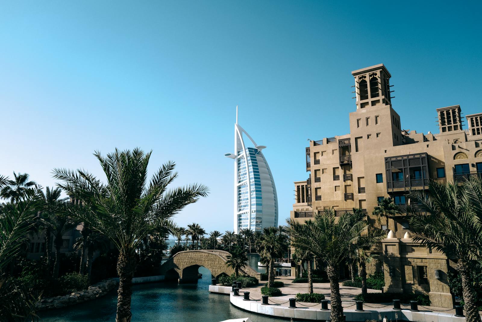 reliable moving and packing services in Jumeriah Village Circle : Beautiful daytime view of Burj Al Arab with palm trees and Jumeirah architecture.